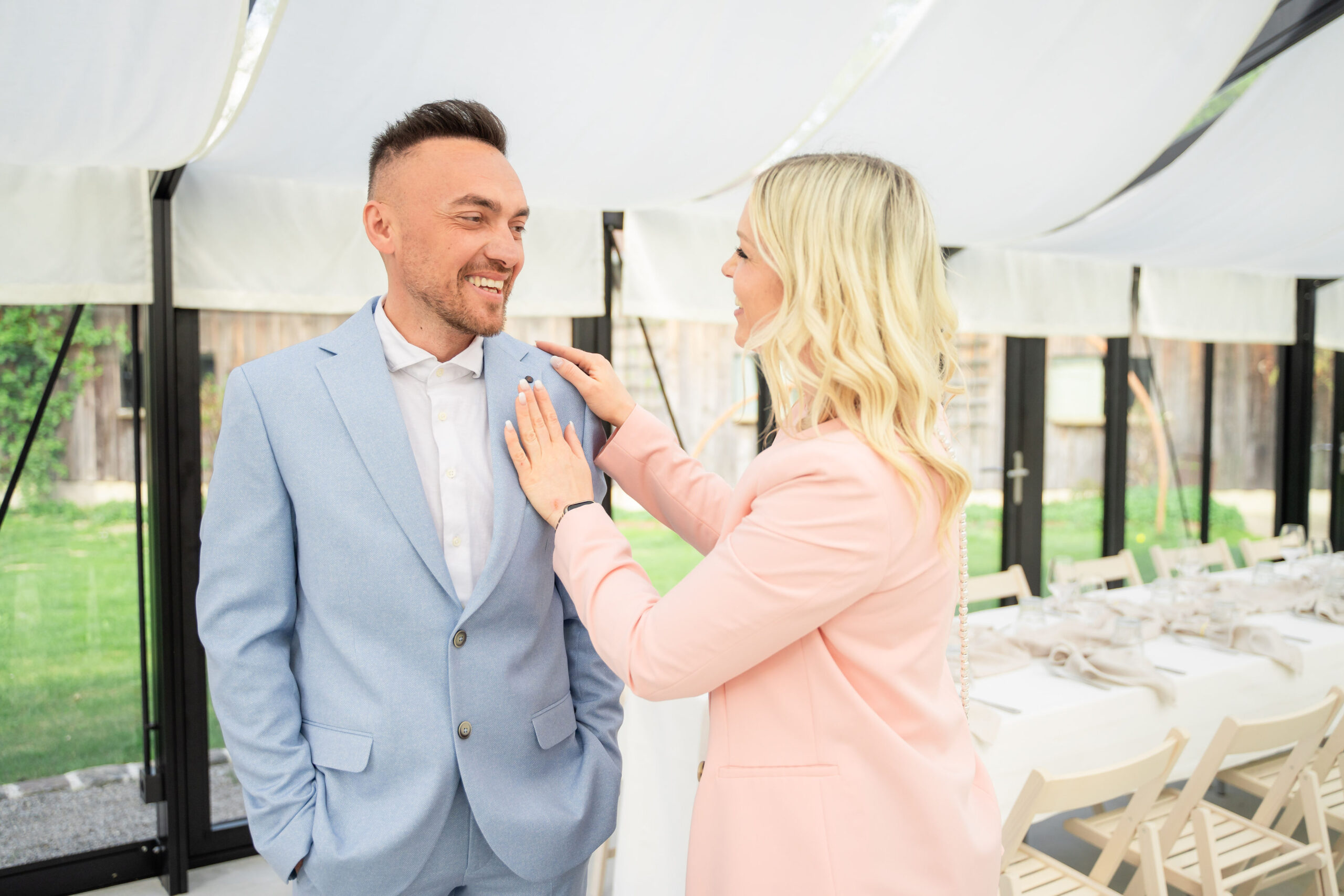 Luxury wedding planner adjusting the groom before an elegant destination wedding in Europe