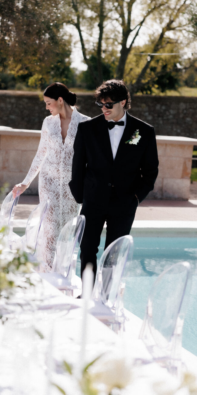 Bride and groom walking along a decorated wedding table during a luxury destination wedding in Europe.