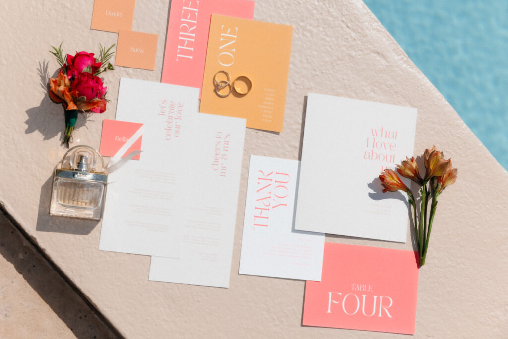 Hochzeitspapeterie Flatlay mit Menükarten, Tischnummern und Eheringen am Pool der Finca Morneta