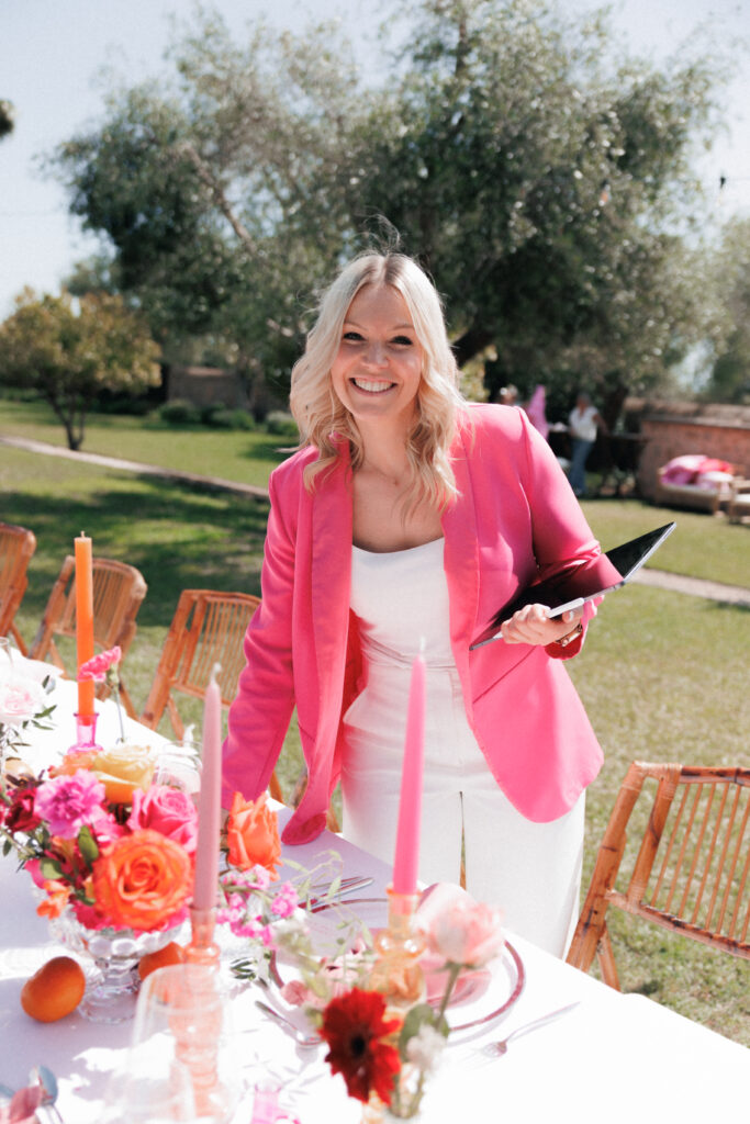 Jessica Schaile, Hochzeitsplanerin Mallorca, lächelt neben festlich gedeckter Hochzeitstafel